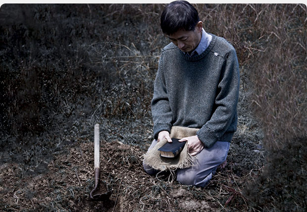 Man kneeling on ground with Bible