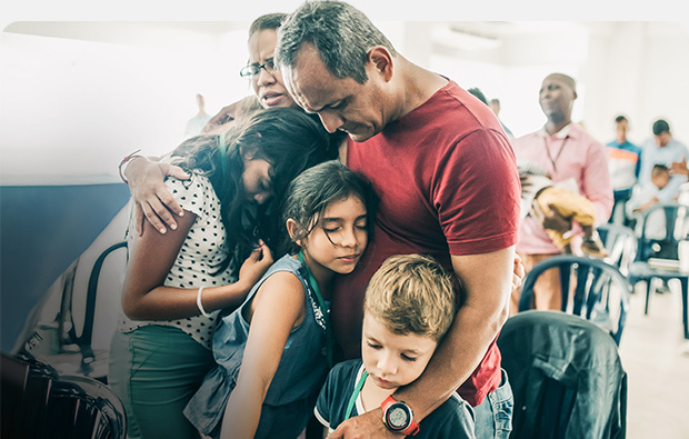 David and Gloria praying with family