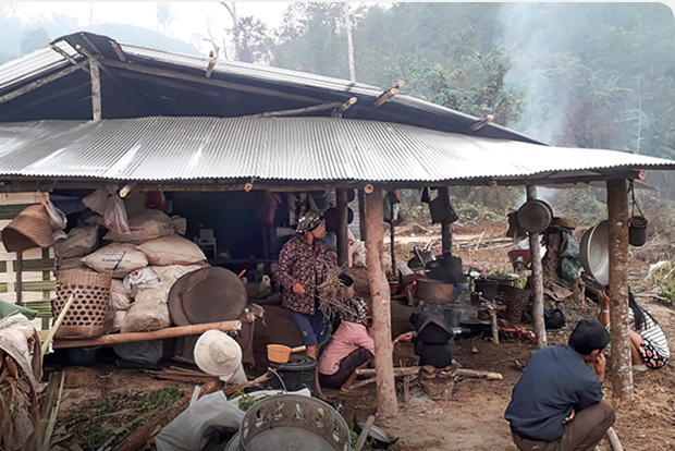 People sitting under a hut in Laos