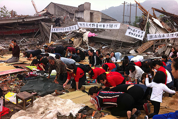 Chinese people praying overtop of demolished homes