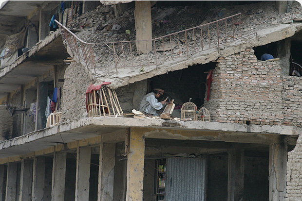 Man kneeling inside destroyed building