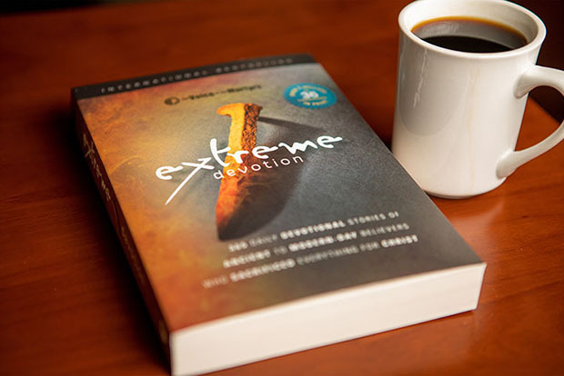 Extreme Devotion book on a table, along with a cup of coffee