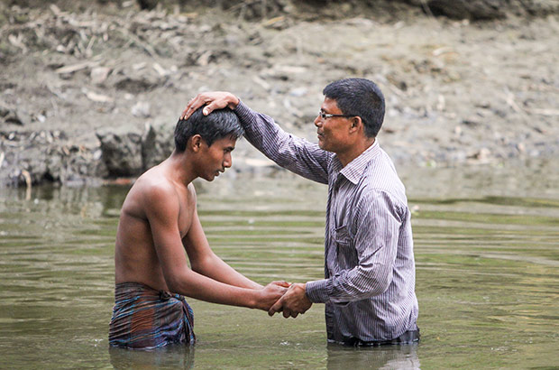 Man baptizing other man